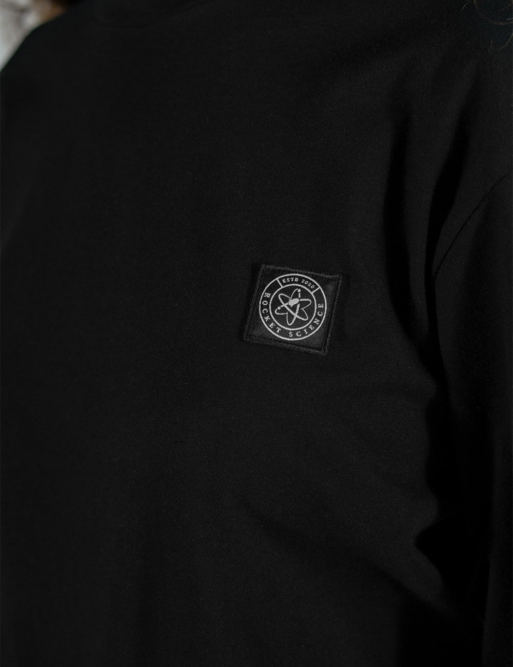This is a close shot of Long sleeve Round Neck Shirt by Rocket Science, featuring a distinctive square logo patch on the chest.