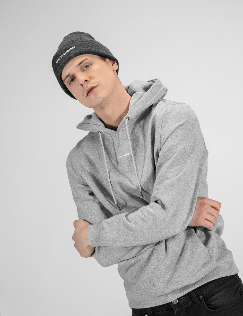 Man showcasing a charcoal heavy-knit beanie with a Rocket Science logo on the front.