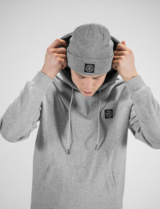 Man showcasing a heather gray heavy-knit beanie with a Rocket Science logo on the front.