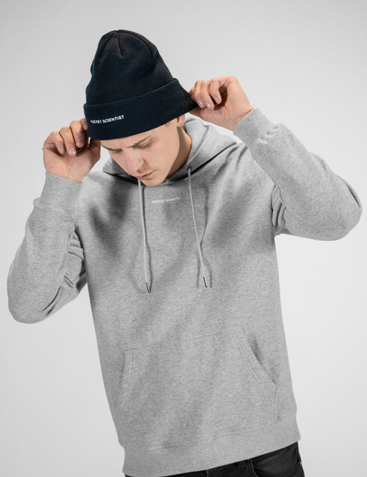 Man showcasing a navy heavy-knit beanie with the words “Rocket Scientist” on the front.