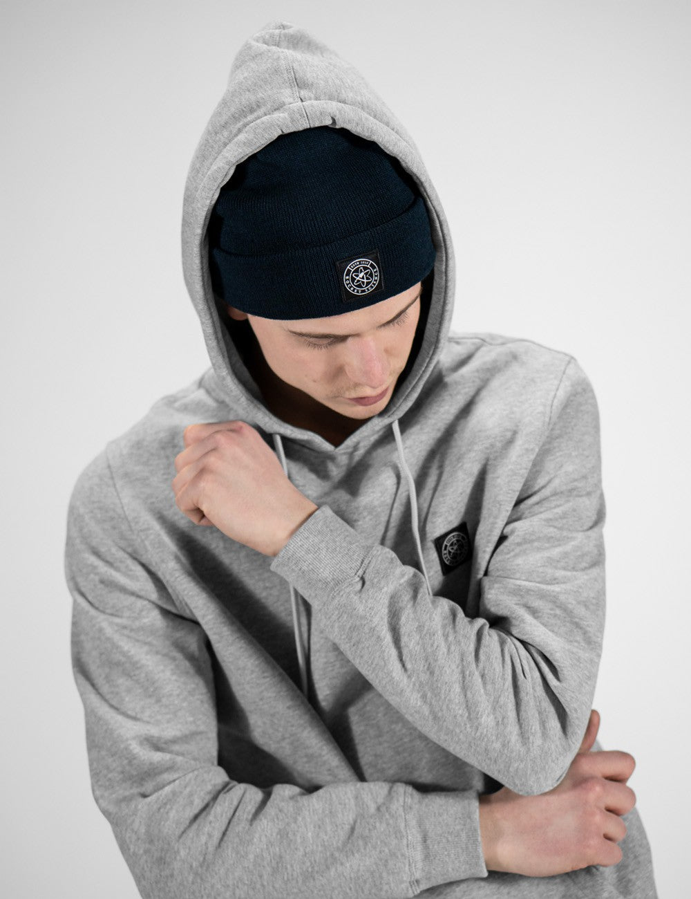 Man showcasing a navy heavy-knit beanie with a Rocket Science logo on the front.