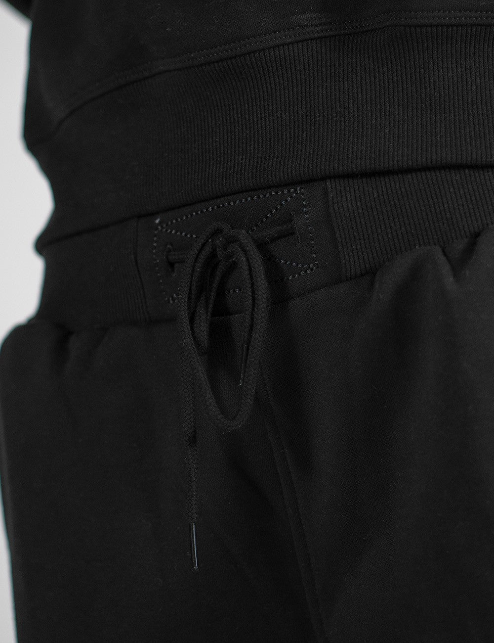 This image shows a pair of black sweatpants with an elastic waistband and matching drawstrings.