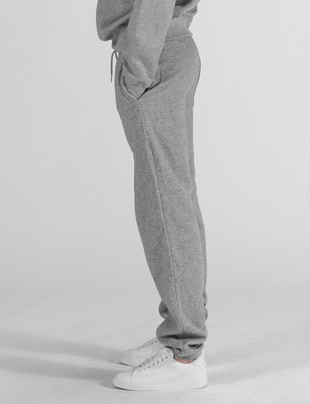 The image shows a pair of grey heather sweatpants with an elastic waistband, drawstrings.