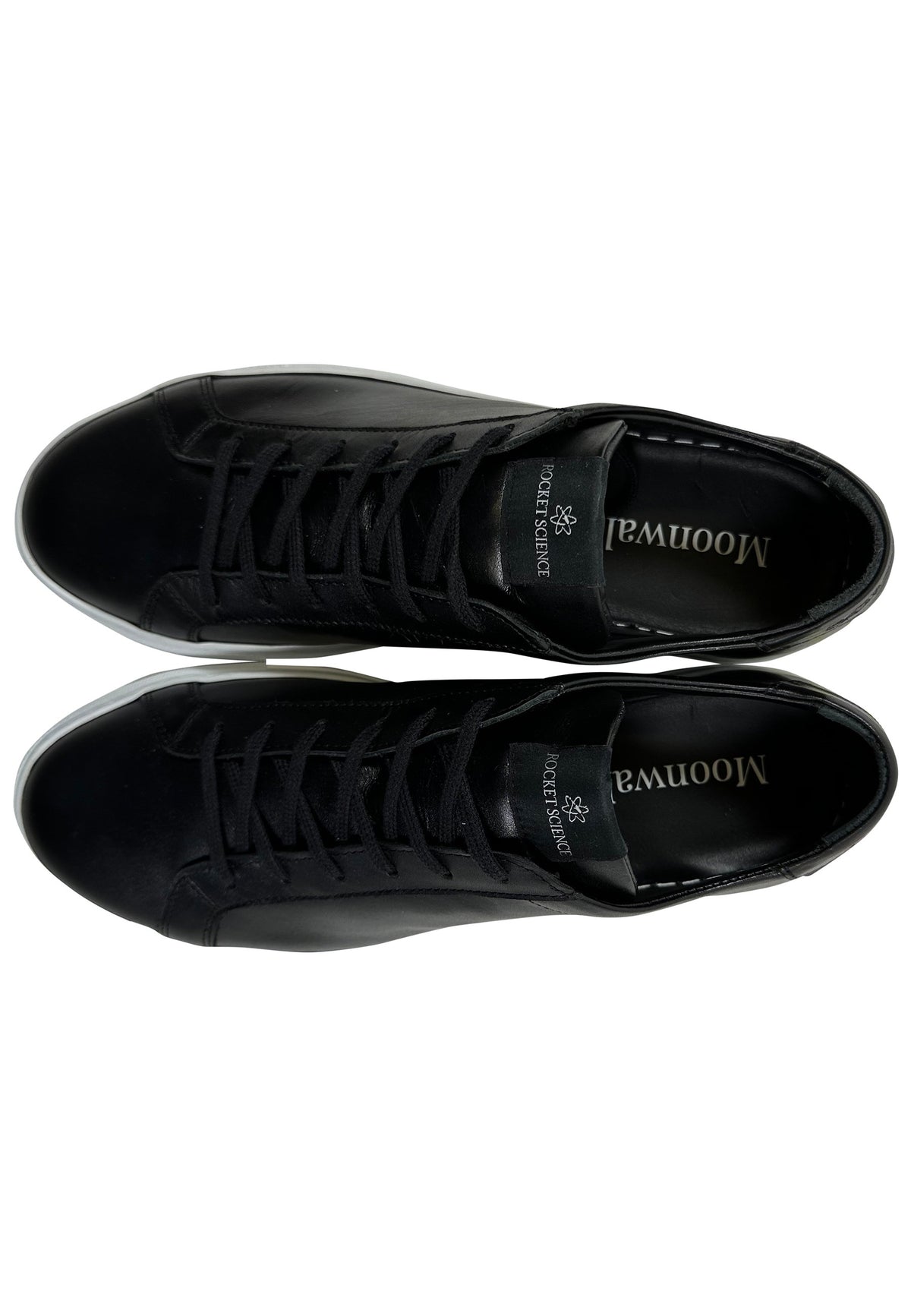 A black suede minimalist low-top sneaker featuring a matching gray lace-up closure and a solid white rubber sole. A distinctive gray rectangular brand tag reading "ROCKETSCIENCE" is stitched onto the tongue of the shoe.