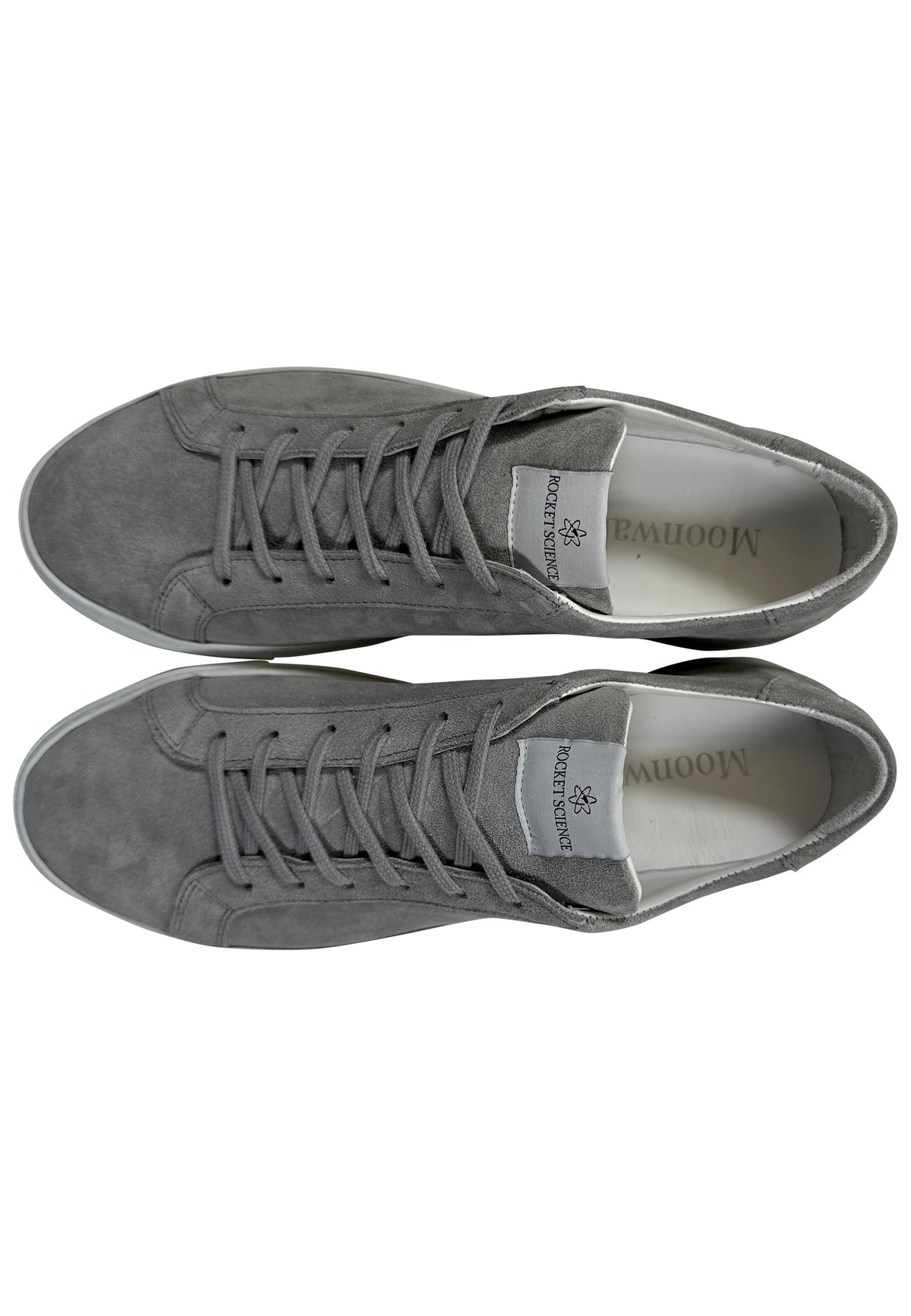 A gray suede minimalist low-top sneaker featuring a matching gray lace-up closure and a solid white rubber sole. A distinctive gray rectangular brand tag reading "ROCKETSCIENCE" is stitched onto the tongue of the shoe.