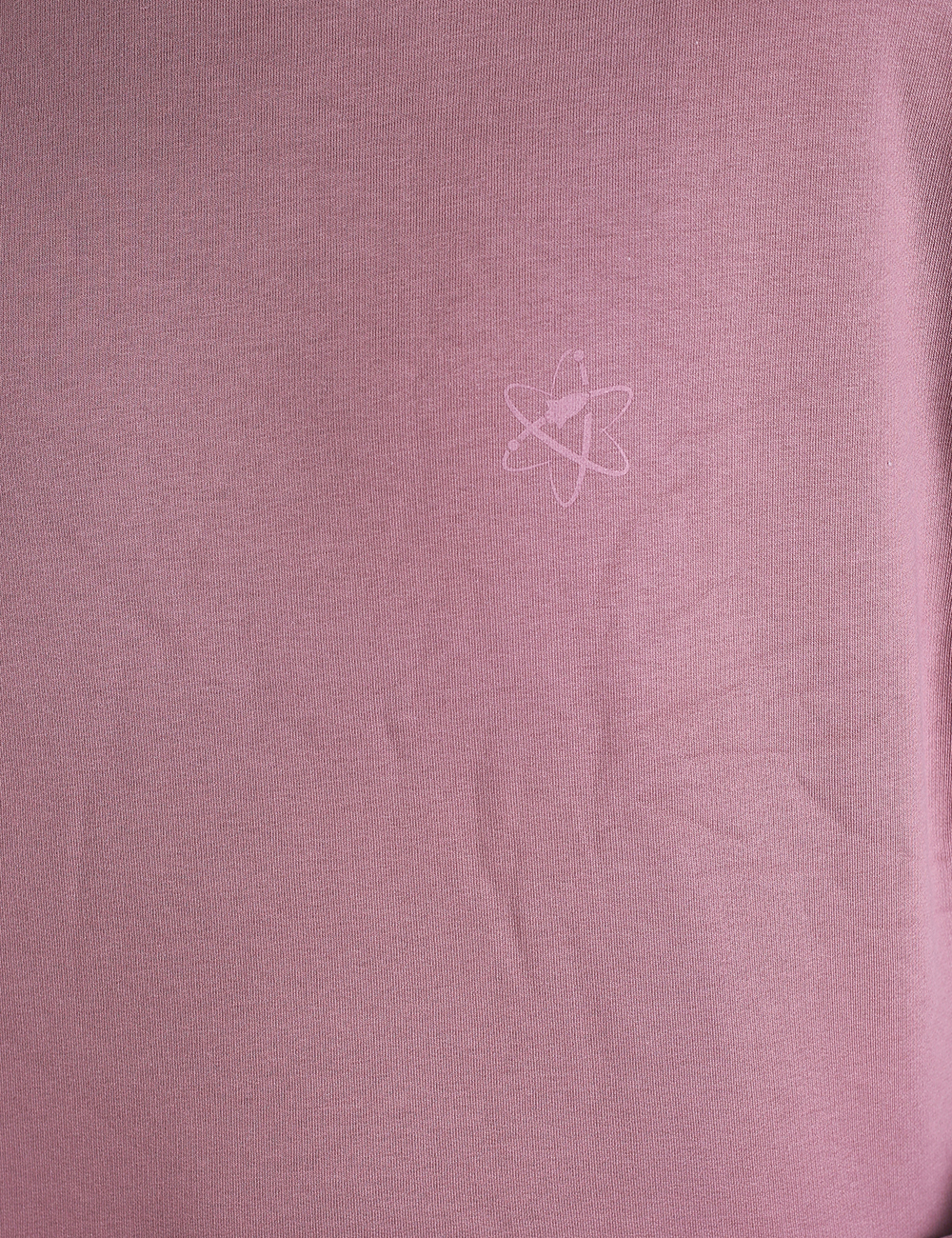 A close-up photograph of a dusty pink or mauve textured fabric. Near the upper center of the image, a subtle, faint logo is visible, consisting of a simplified atom design with an electron orbit and an upward-pointing arrow integrated into the center.