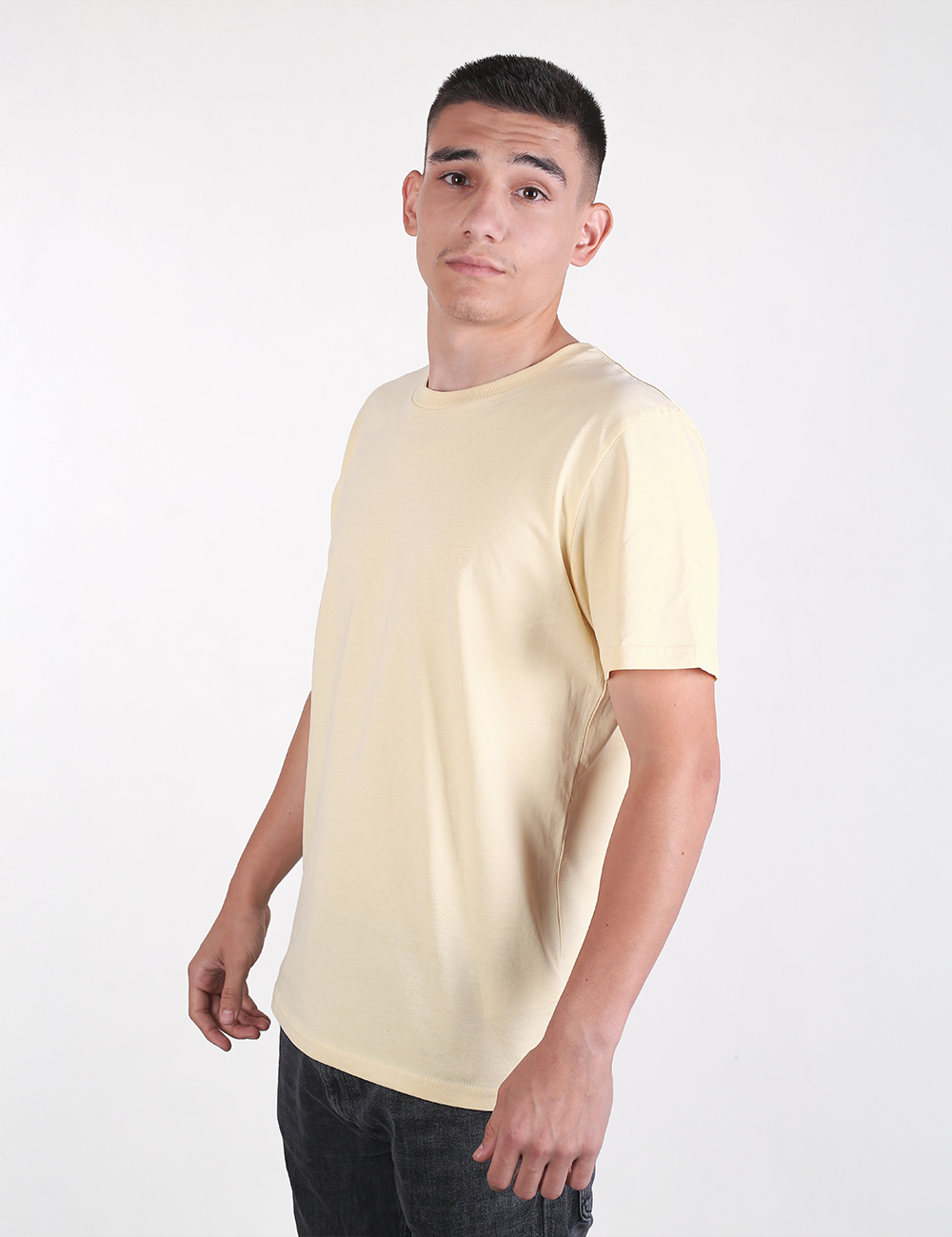 The person in the image is wearing a light yellow crew neck t-shirt that resembles the Organic Cotton T-Shirt, Butter from Rocket Science.