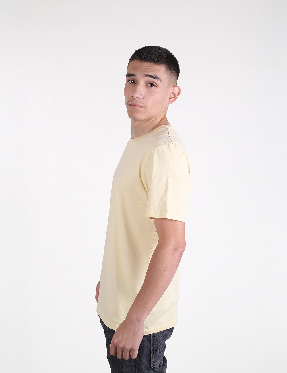 The person in the image is wearing a light yellow crew neck t-shirt that resembles the Organic Cotton T-Shirt, Butter from Rocket Science.