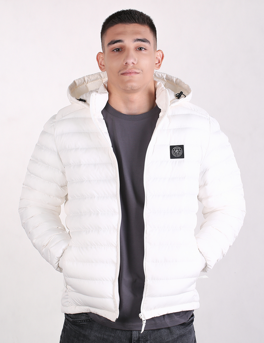 A man wearing a white hooded puffer jacket over a dark gray t-shirt, standing against a plain light background.
