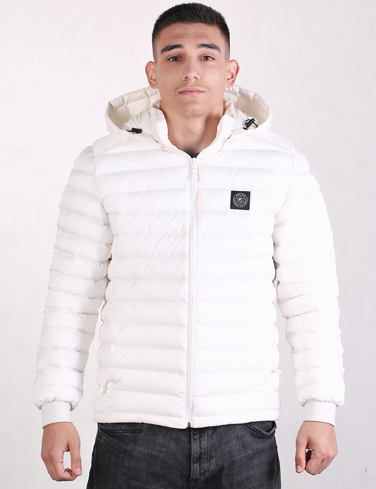 A man wearing a white puffer jacket with a zip-up front, hood, and a small black logo patch on the left chest, paired with dark gray jeans, against a plain white background.