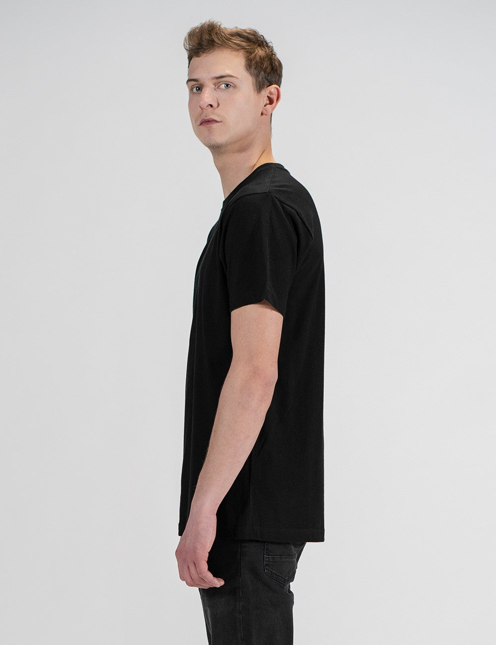 Man showcasing a black round-neck T-shirt with the words “Rocket Scientist” on the front.