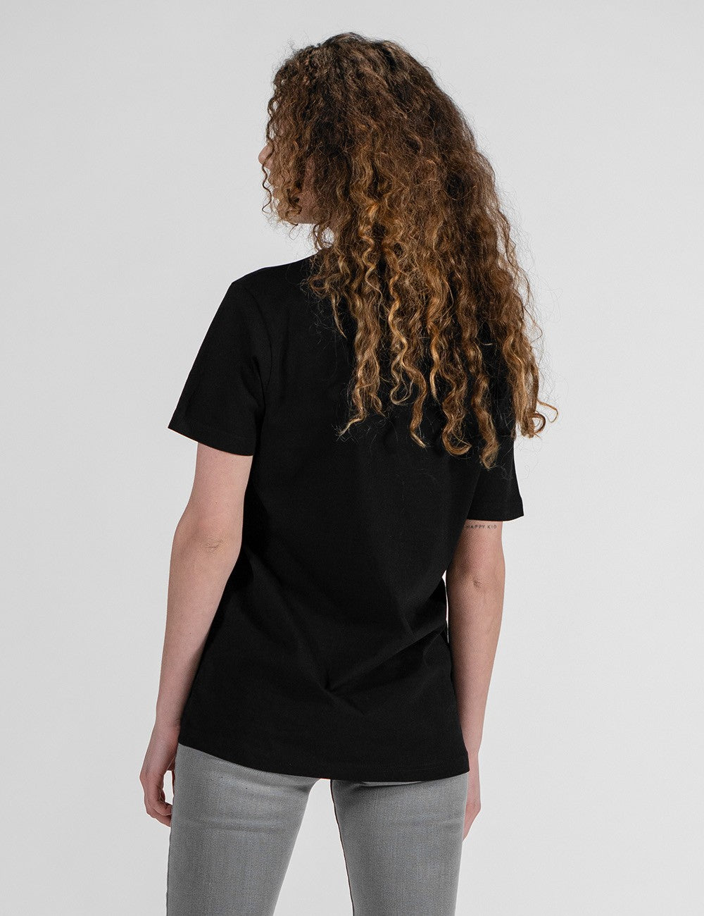 Woman showcasing a black round-neck from the back.
