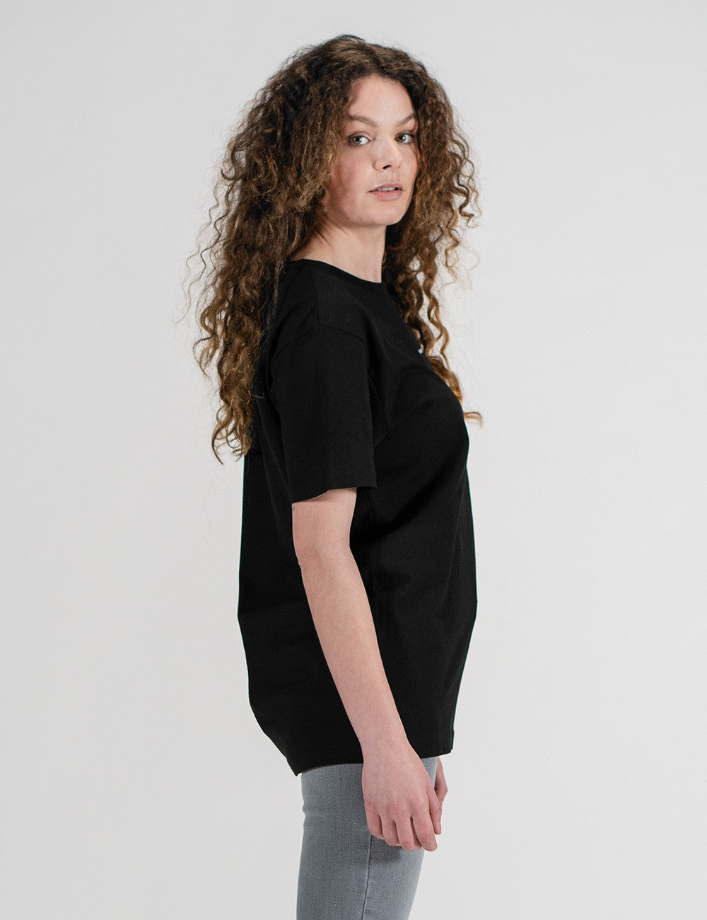 Woman showcasing a black round-neck T-shirt with the words “Rocket Scientist” on the front.