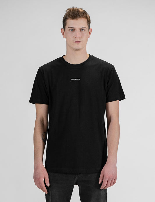 Man showcasing a black round-neck T-shirt with the words “Rocket Scientist” on the front.
