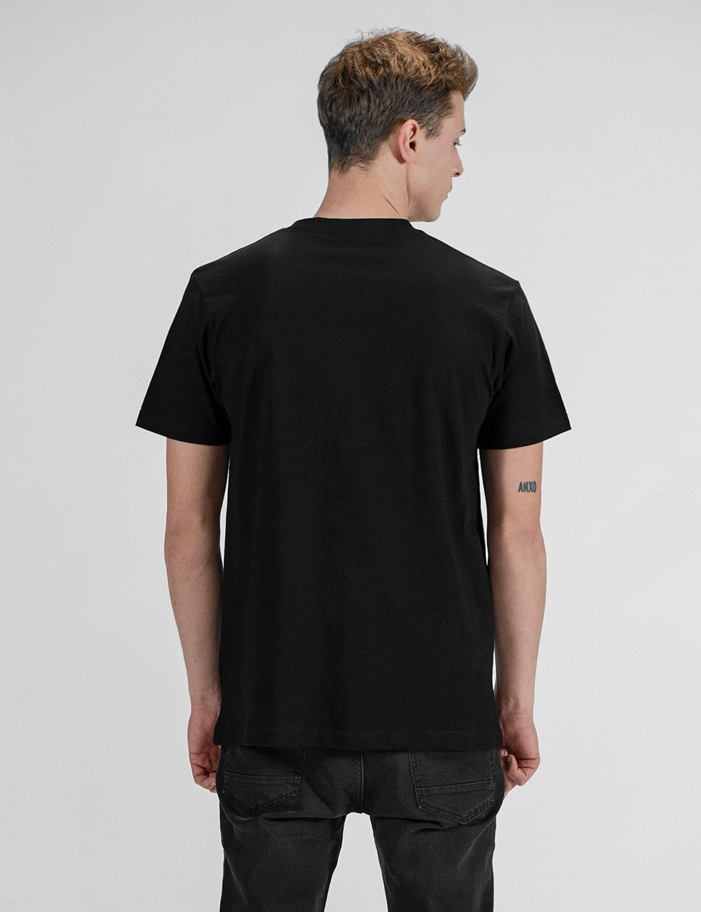 This image shows a rear pose of a young man , wearing a black cotton crew-neck t-shirt.