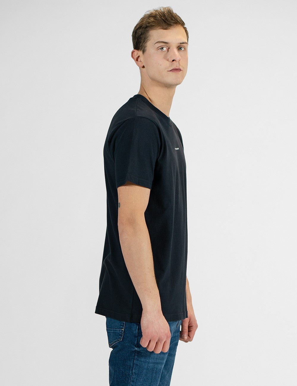 Man showcasing a navy round-neck T-shirt with the words “Rocket Scientist” on the front.