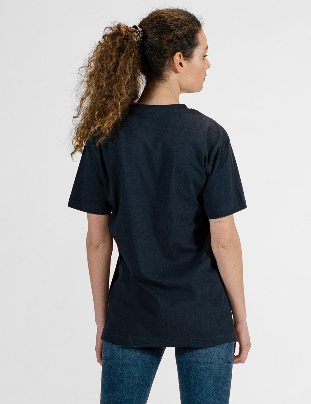 Woman showcasing a navy round-neck T-shirt from the back.