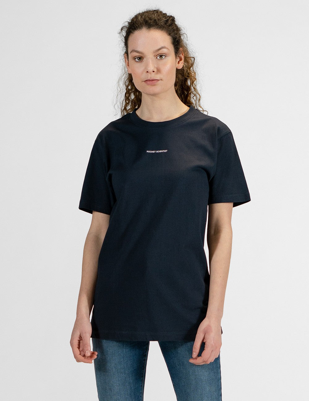 Woman showcasing a navy round-neck T-shirt with the words “Rocket Scientist” on the front.