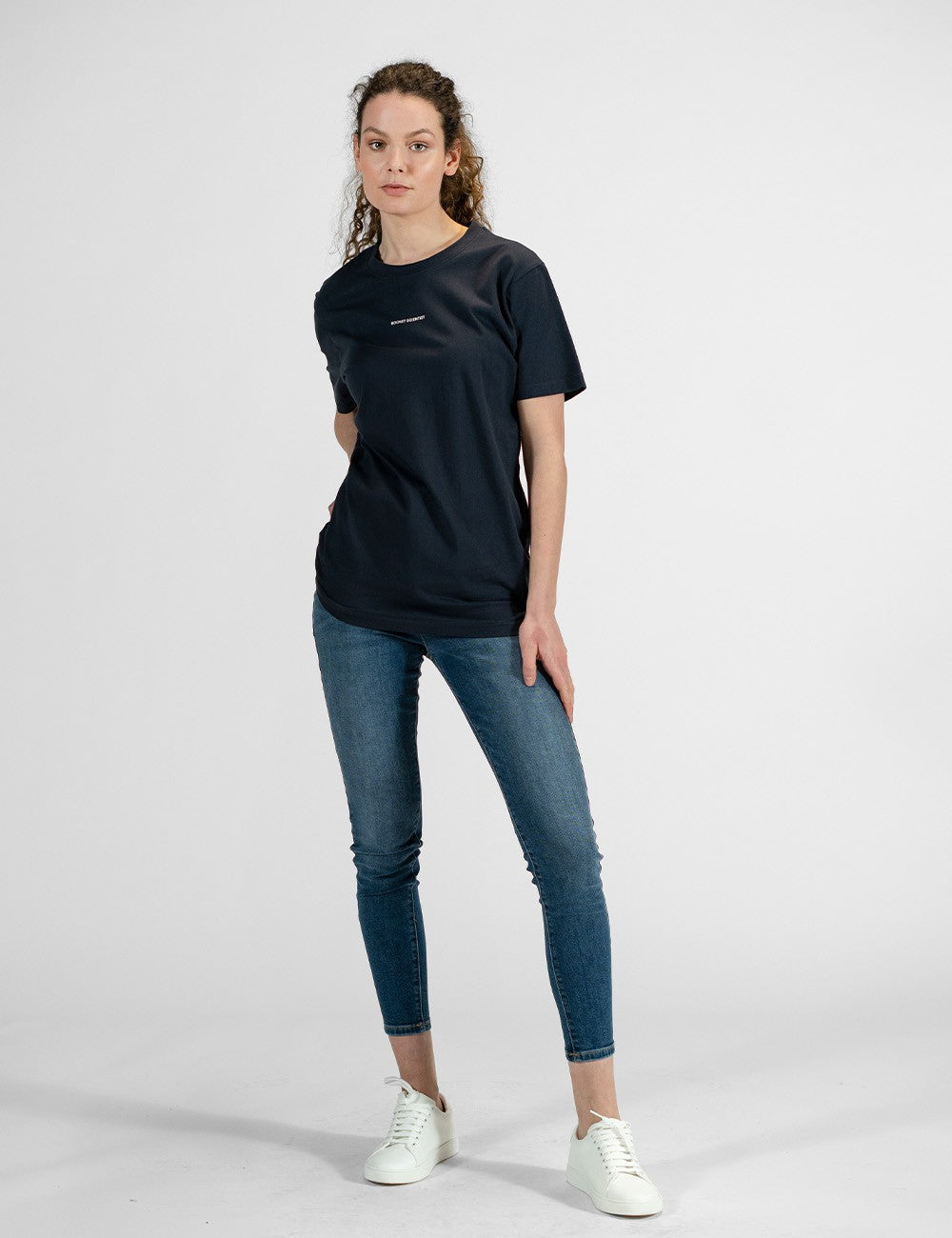 Woman showcasing a navy round-neck T-shirt with the words “Rocket Scientist” on the front.