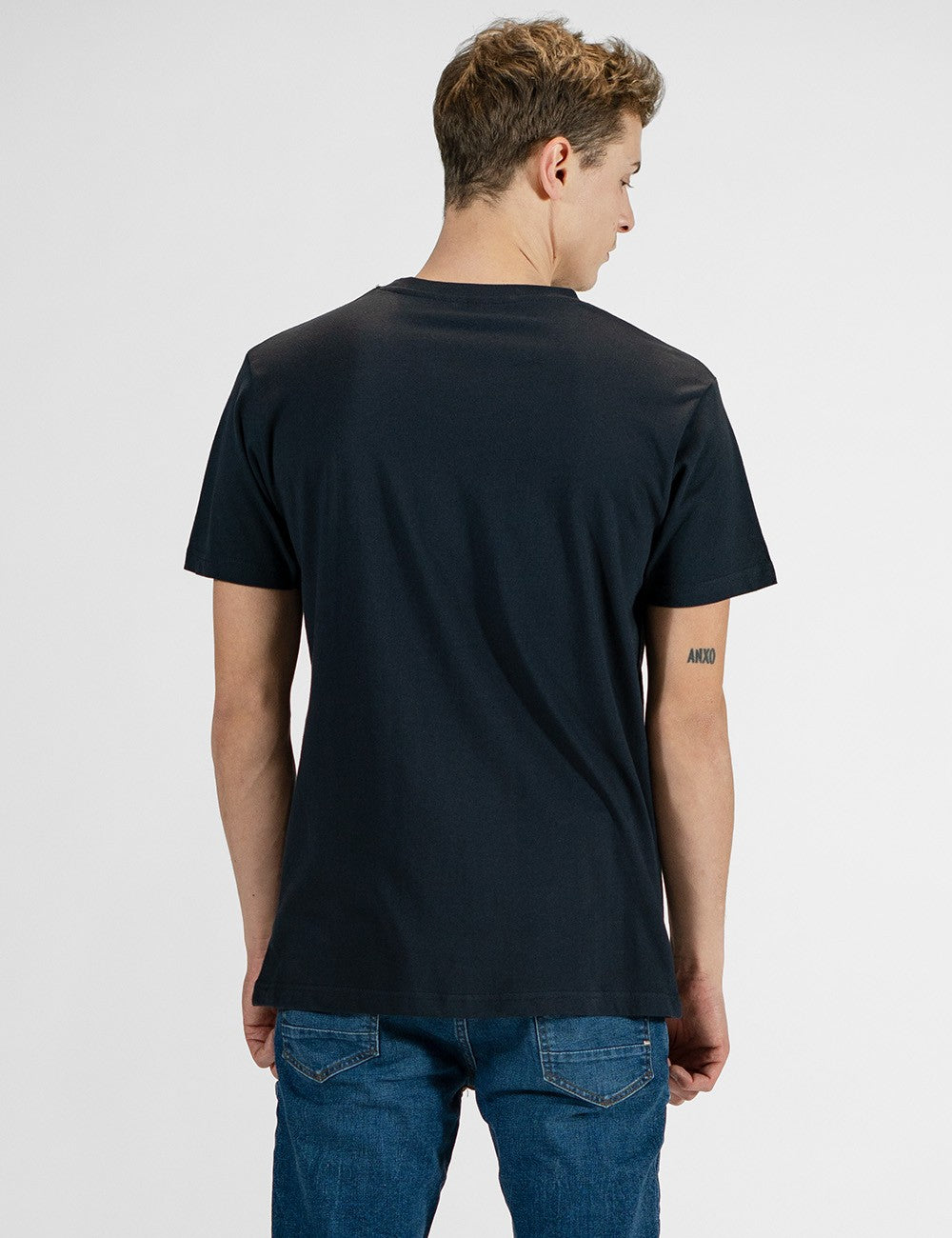 Navy blue crew neck t-shirt worn by male model, rear view
