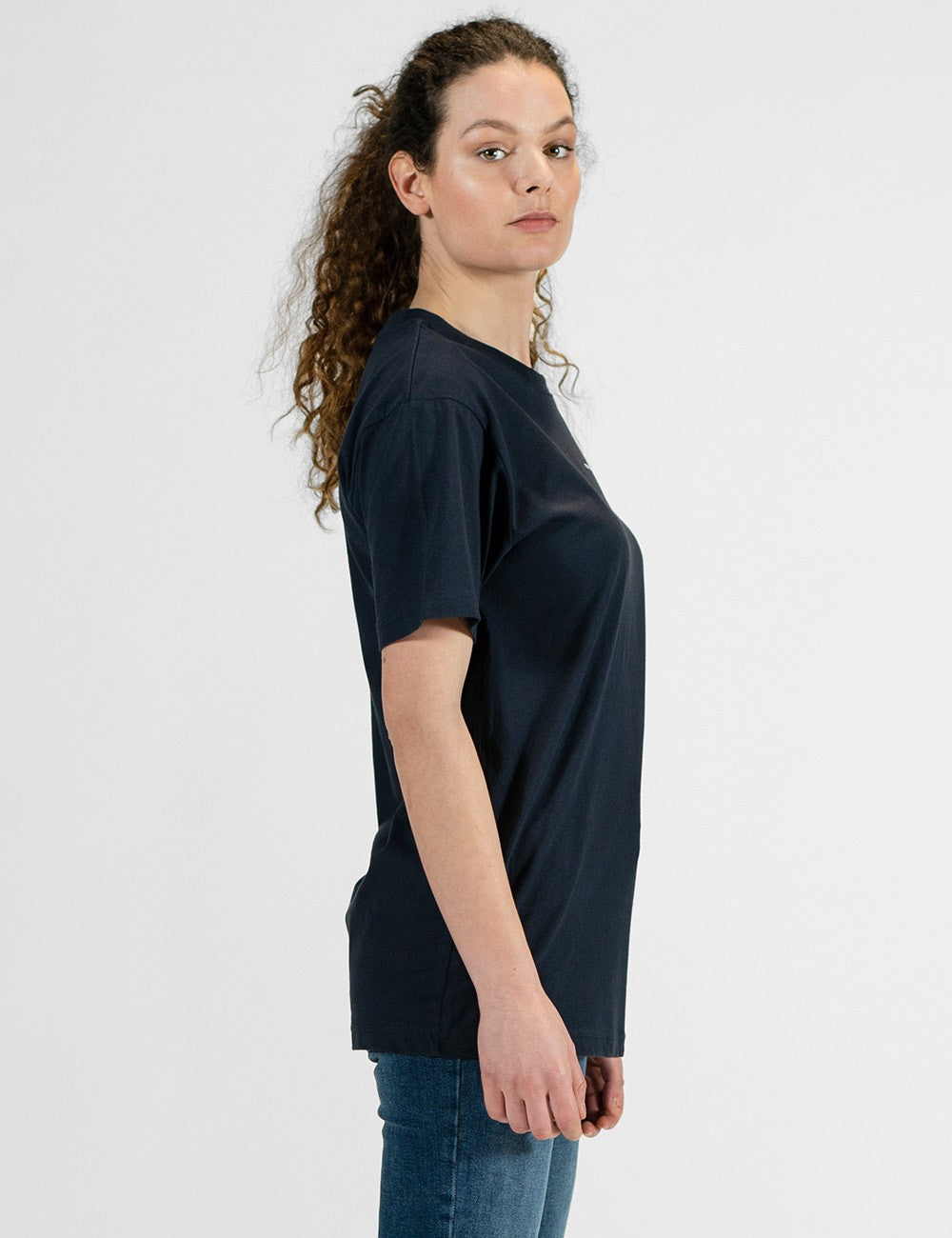 Woman showcasing a navy round-neck T-shirt with the words “Rocket Scientist” on the front.