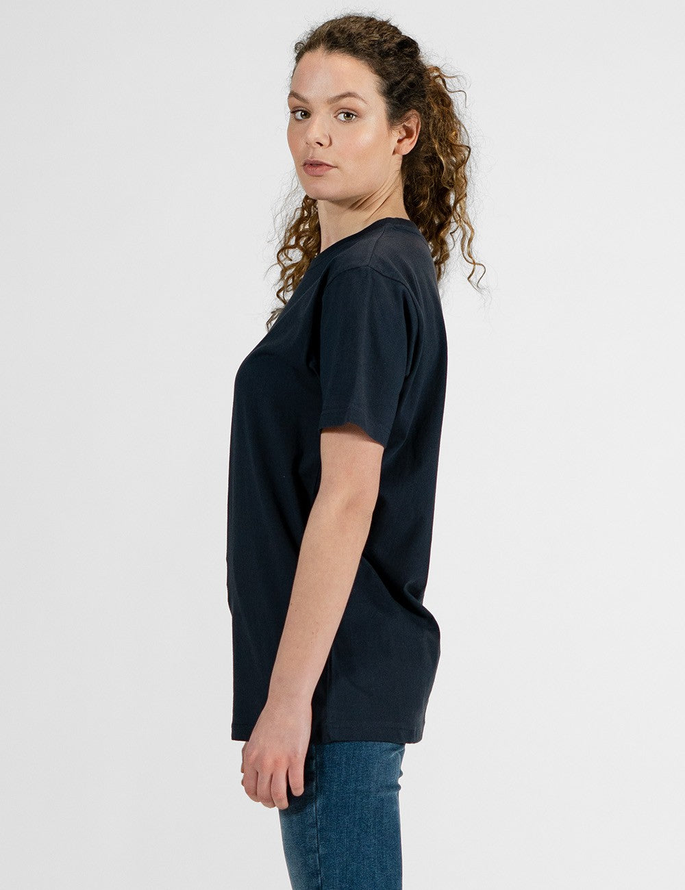 Woman showcasing a navy round-neck T-shirt with the words “Rocket Scientist” on the front.