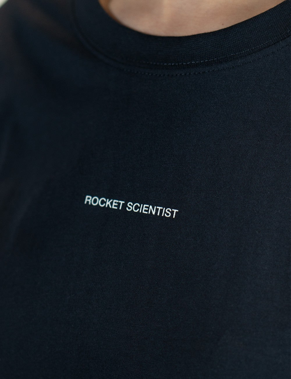 Black round-neck T-shirt with the words “Rocket Scientist” on the front.